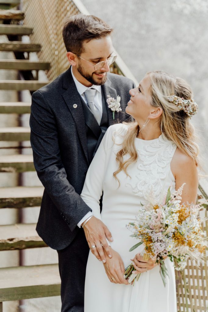 Supertocadas, tiara de flores y piedras como tocado de novia con el pelo semirecogido